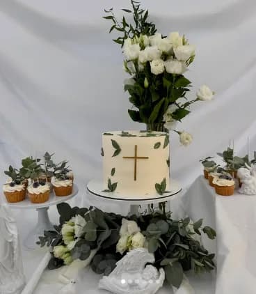 Sweet table de baptême : gâteau à la croix dorée, cupcakes et fleurs blanches avec feuillage d'eucalyptus — Poppy's Cakes Deauville